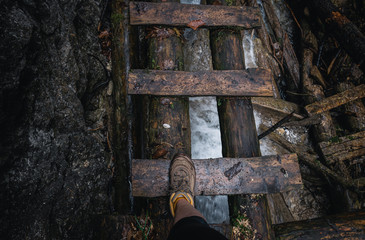Wooden ladder above Sucha Bela river with hiking boot. 