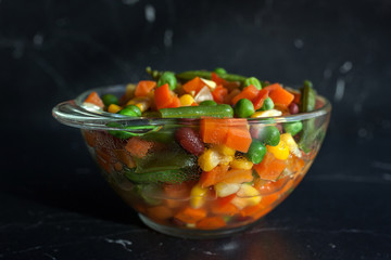 steamed vegetables on plate at dark background