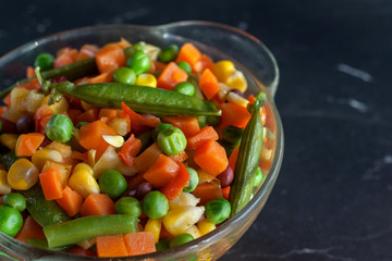 steamed vegetables on plate at dark background