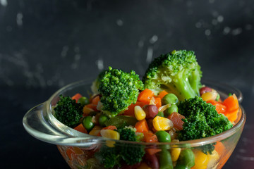 steamed vegetables on plate at dark background