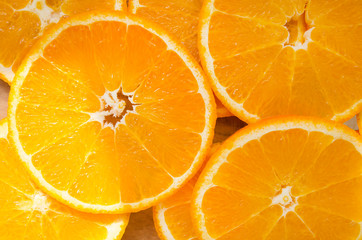 Pattern made with slices of juicy orange with tough sunshine spots, top view