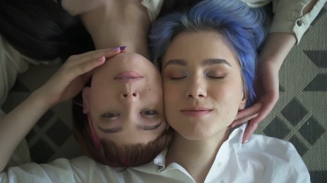 portrait of two ager young womans lying and looking at camera. Spbd gay lesbian friends feeling relaxed and chilling. concept tolerance, lgbt, enjoyment. woman s bonding together. top view