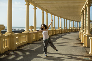 Multicultural woman does outdoor choreography on the atlantic promenade. Porto, Portugal.