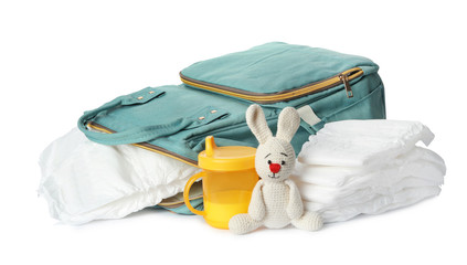Backpack with disposable diapers and child's accessories on white background