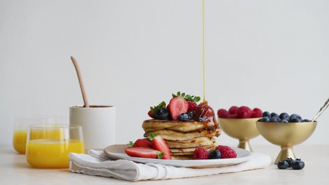 A stack of sourdough pancakes with berries and honey drizzle