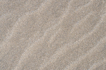 Fototapeta na wymiar Closeup of sand pattern of a beach in the sunny day