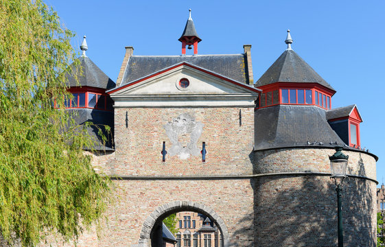 Exit side of the Ezelpoort (gate for the donkeys) in Bruges against blue sky. One of the four remaining original entrance gates to the inner city of Bruges