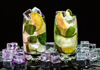 Mojito in a glass cup with lime, mint and ice  on a black background