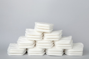Pile of baby diapers on light grey background