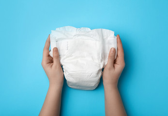 Woman with diaper on light blue background, closeup - obrazy, fototapety, plakaty