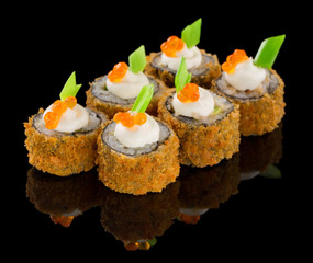 Hot Fried Futomaki Sushi roll with sauce, caviar and chive ot top isolated on black background with reflection