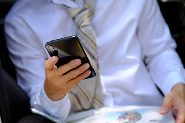 businessman using mobile phone and reading a newspaper
