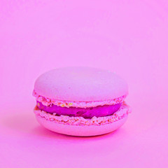 Sweet almond colorful unicorn pink macaron or macaroon dessert cake isolated on trendy pink pastel background. French sweet cookie. Minimal food bakery concept Copy space