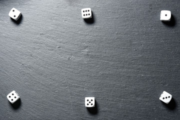 Black stone blackboard with playing dice on