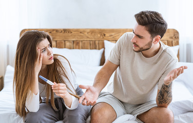 Problems with conceiving concept. Frustrated husband and wife sitting on bed