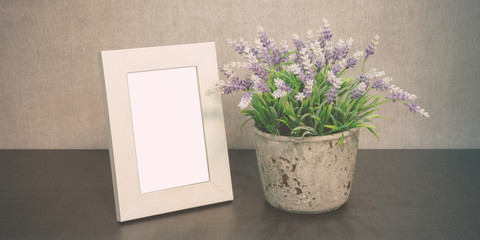 white empty photo frame and flowerpot with flowers home interior