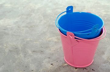 multi-colored empty mini buckets on gray background. Aluminum bucket for flower garden for the manufacture of accessories for the home and garden. floriculture planting plants summer season seedlings