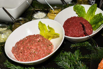 Beef tartar with various sauces dressings during hotel brunch buffet outside outdoor in the garden by the pool