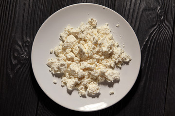 Homemade cottage cheese in a bowl on old wooden table