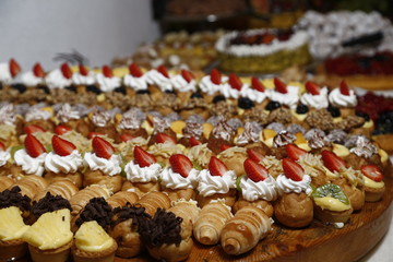 buffet with sweets. fruits and other sweets on dessert table. Rows of tasty looking desserts in beautiful arrangements. Sweets on banquet table - picture taken during catering event