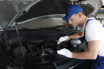 Fototapeta na wymiar Professional auto mechanic fixing modern car in service center
