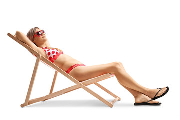 Young woman in bikini sunbathing on a lounge chair