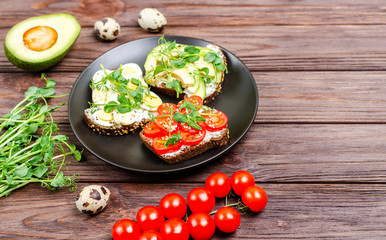 Variety of mini sandwiches with cream cheese and vegetables in a black plate.