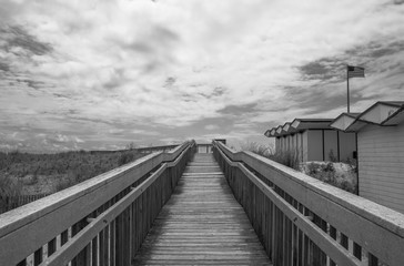Fototapeta na wymiar Outdoor wooden boardwalk walkway, with sky and cloud background. Beach cabana pier plank bridge.