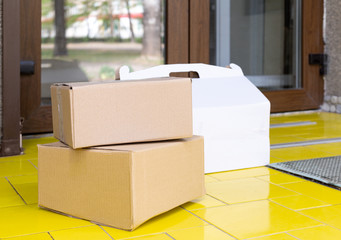Delivery boxes on doorstep at home. Contactless food delivery. Safe shopping E-commerce purchase parcels at home. Boxes delivered to front door by courier, postman