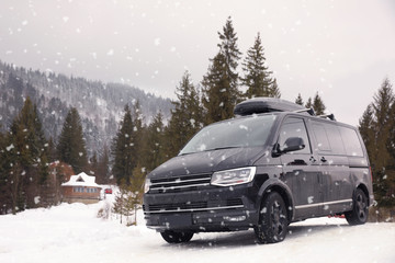 Black car on snowy road. Winter vacation © New Africa