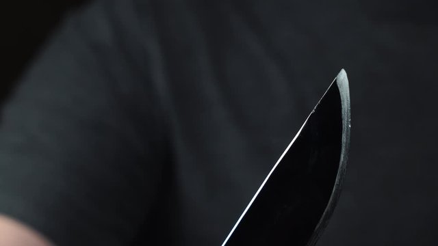 Man holding a hunting knife in his hand close-up blade