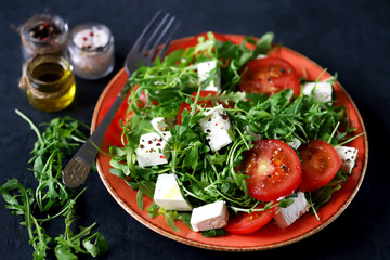 Selective focus. Macro. Salad with arugula, tomato and feta cheese. Nutritious super salad. Keto diet. Keto lunch.