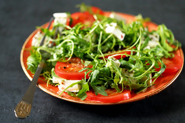 Selective focus. Macro. Salad with arugula, tomato and feta cheese. Nutritious super salad. Keto diet. Keto lunch.