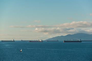 Tanker and Freighter Ships Wait in Burrard Inlet Vancouver, British Columbia to load and unload at the Port of Vancouver