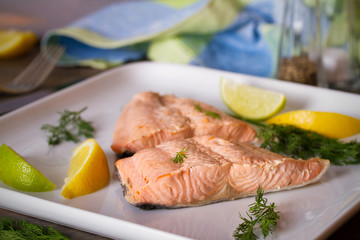 Steam cooked salmon with lemon and dill on white plate. Healthy diet detox food concept