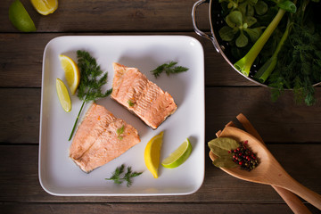 Steam cooked salmon with lemon and dill on white plate. Healthy diet detox food concept. Flat lay,...