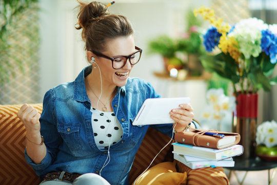 happy female with white headphones and tablet PC rejoicing