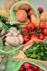 Vegetable in reusable bags on wood background, top view