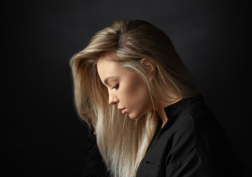 Dramatic studio portrait of beautiful young woman on dark background.