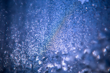 patterns on glass, frosty drawings in winter on a window, blue background and ice drawings, droplets of fody, reflection through glass,