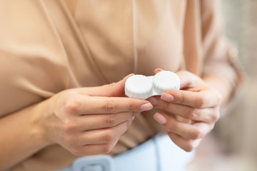 Young girl holding contact eye lenses container