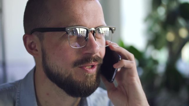man office worker talking on the smartphone with smile in office closeup. Spbd business discussion. modern technology and employee concept. man discussing working proccess details