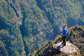 Obraz premium Young man on a trekking in the mountains. Trekker walking on the mountains. Success, freedom and happiness, achievement in mountains