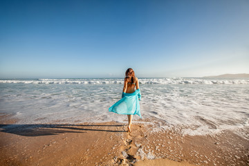 Fototapeta na wymiar Woman enjoying sunny day on the tropical caribbean sandy beach landscape with turquoise sea and blue sky 