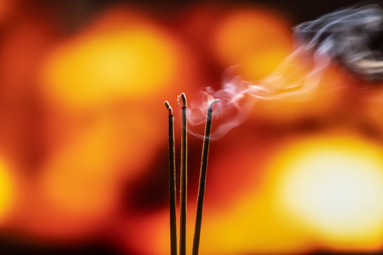Burning Incense Sticks with smoke, joss sticks burning at a vintage Buddhist temple