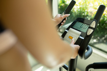 Close-up. The girl changes the settings of the Control Panel on the simulator in the fitness room.