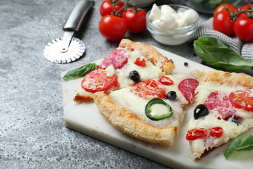 Composition with pieces of delicious pizza Diablo on  dark background, closeup