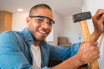 Latin man repairing his house during quarantine.