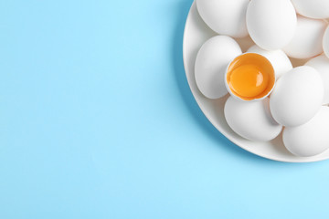 Fresh raw chicken eggs on light blue background, top view. Space for text