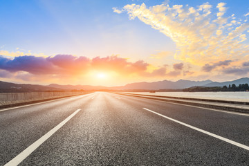 Naklejka premium Asphalt road ground and mountain landscape at sunset.